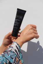 Load image into Gallery viewer, Revision Skincare Intellishade Matte SPF 45 applied to a female&#39;s wrist. Exclusie Beauty Club is a proud authorized retailer of Revision Skincare.
